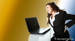 a person Nashua bending over a computer holding her back due to pain